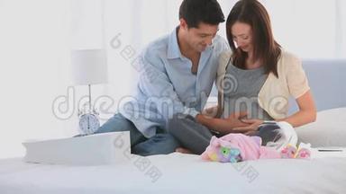 幸福的未来父母在他们的床上